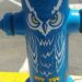 Fire hydrant painted blue with an owl desgin.